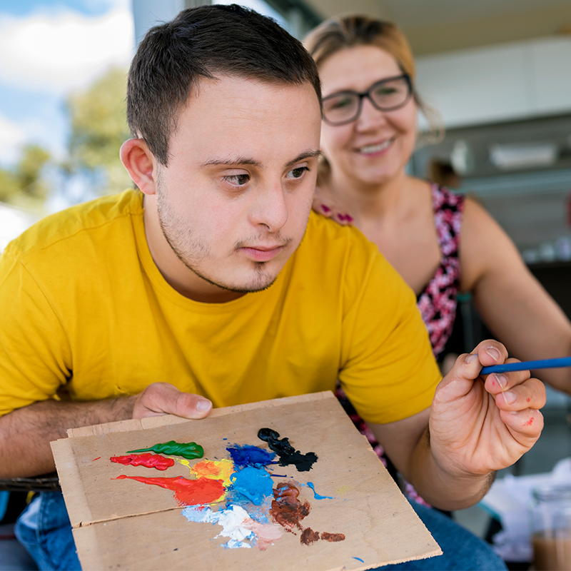 Young man with a disability painting